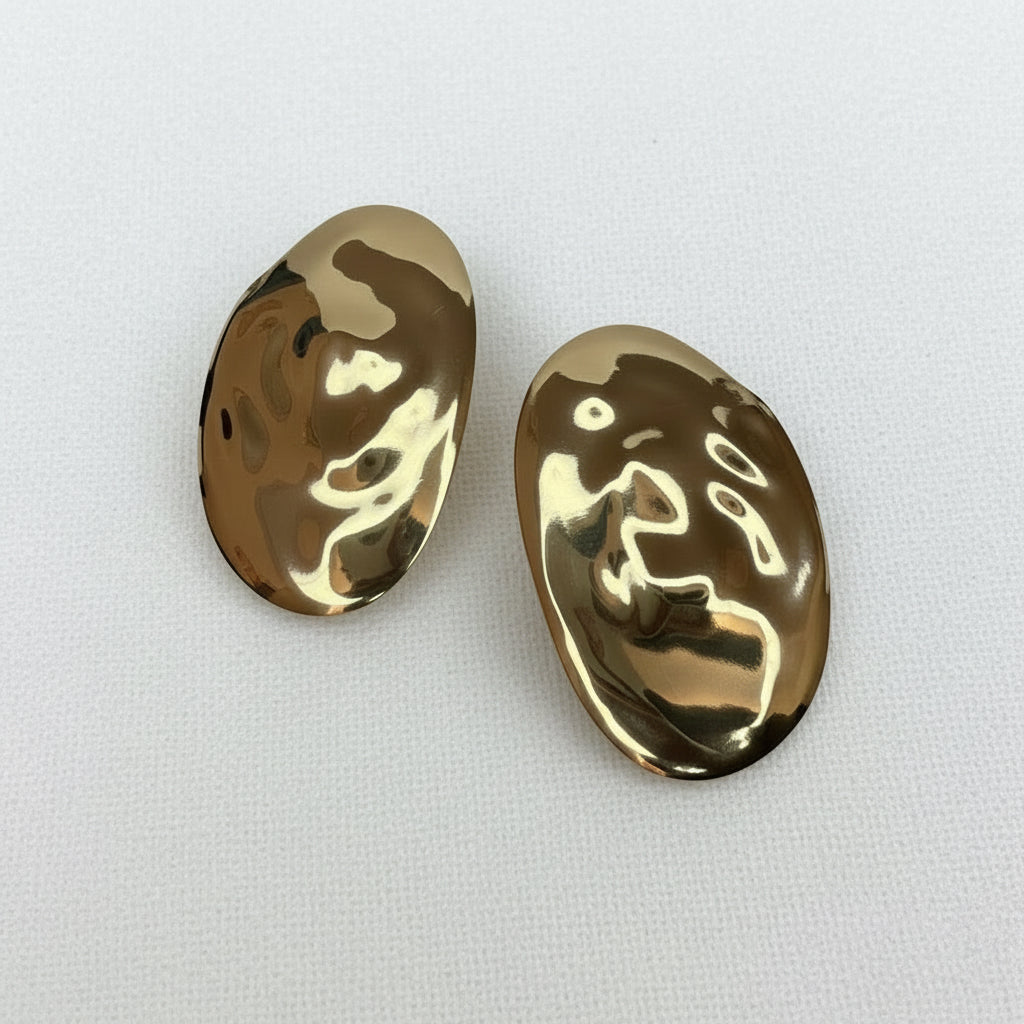Two gold oval-shaped hammered texture earrings  on a white background
